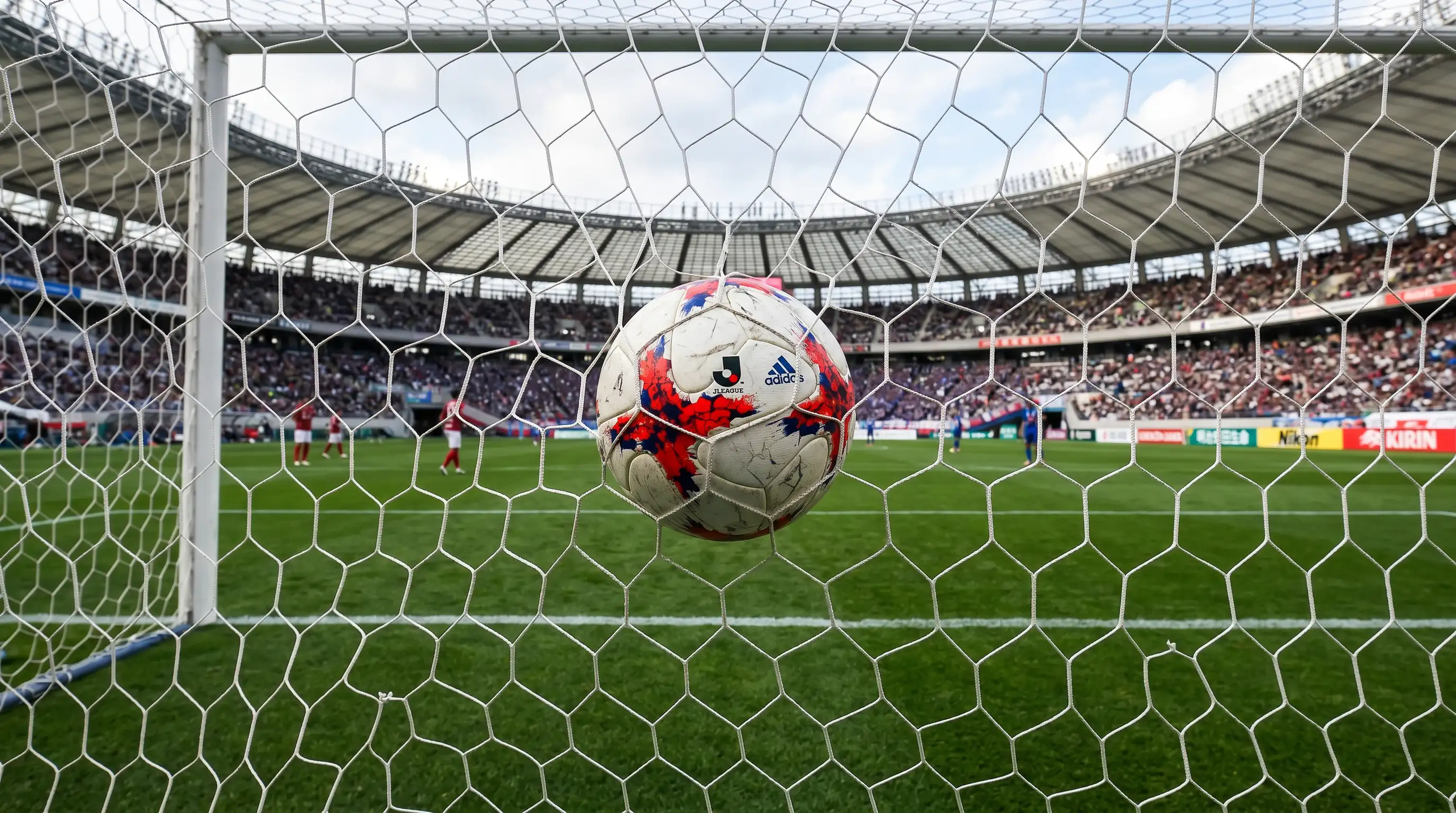 Balón de fútbol en la red de una portería de un estadio japonés tras un gol