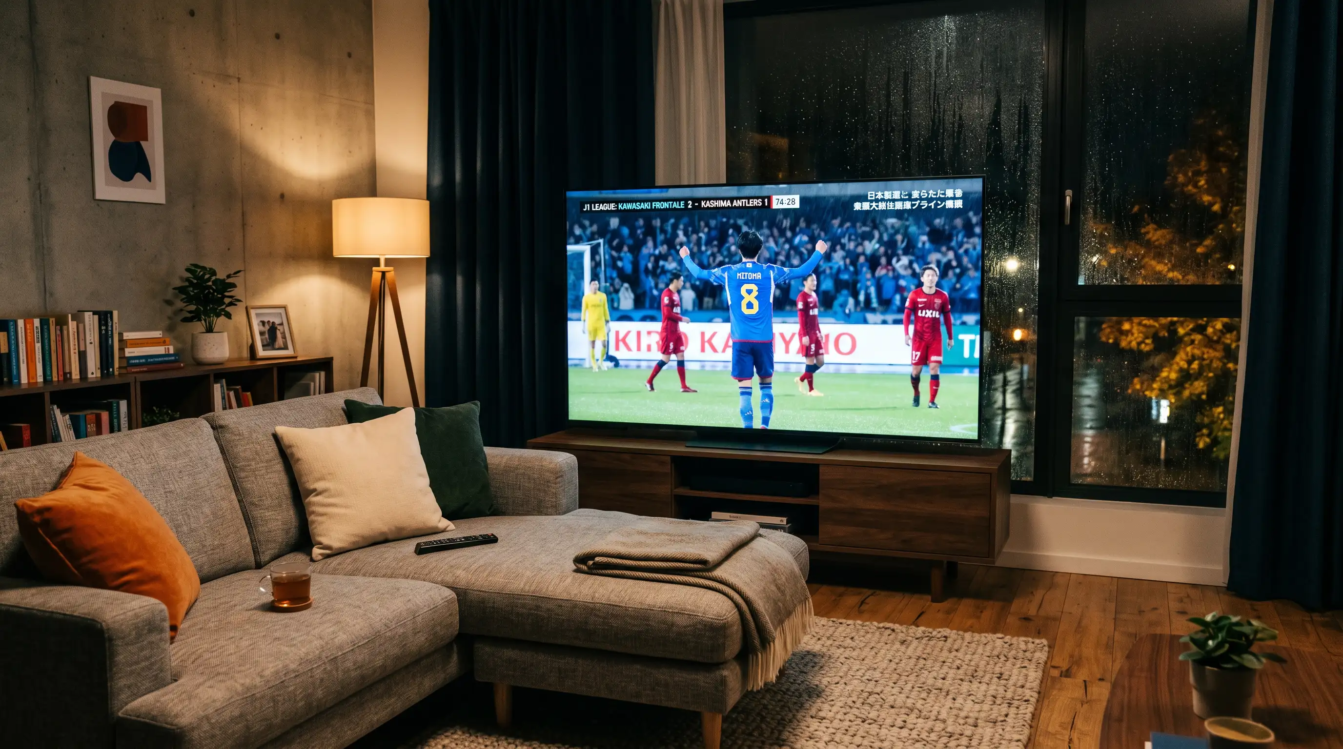 Televisor de pantalla grande mostrando un partido de fútbol de la J-League en un salón
